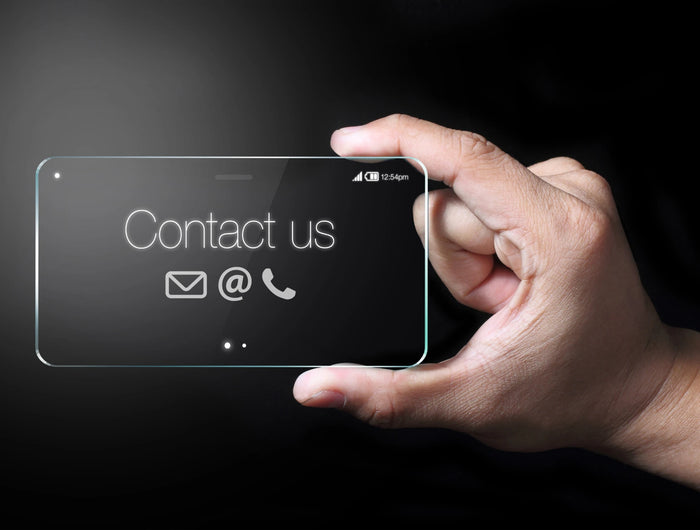 Hand holding a transparent phone screen with 'Contact us' text and icons on a dark background