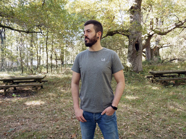 Man standing in a forested area with picnic tables wearing hemp and organic cotton tshirt.