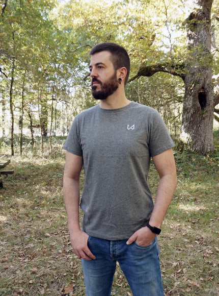 Man standing in a forested area with picnic tables wearing hemp and organic cotton tshirt.