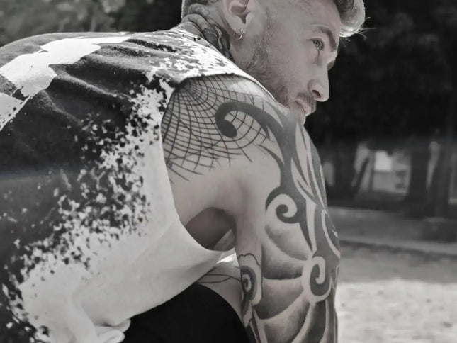 Man with tattoos on his arms sitting outdoors