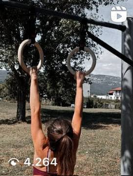 Atleta donna che esegue trazioni su anelli di dinamica selvaggia