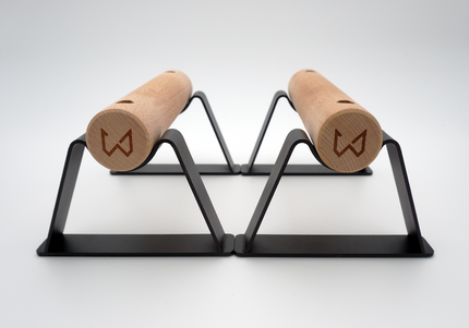 A pair of Antlettes Parallettes with a black powder-coated steel base and wooden handles, designed for calisthenics and bodyweight exercises.