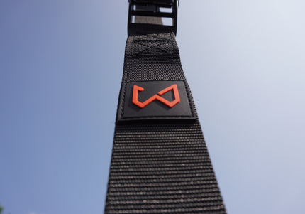 Black strap with a red logo of wild dynamics with blue sky in background