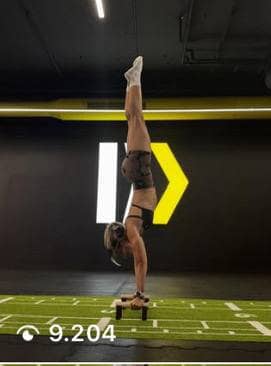 Atleta di calisthenics che esegue la verticale sulle parallele