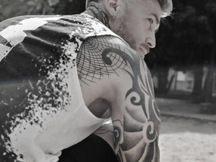 Man with tattoos on his arms sitting outdoors