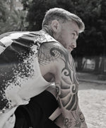 Man with tattoos on his arms sitting outdoors