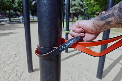 Person using a resistance band on outdoor exercise equipment