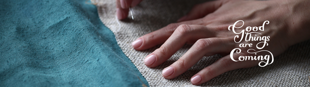Close-up of hands on fabric with 'Good Things are Coming' text