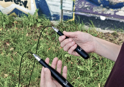 Person holding a jump rope with graffiti in the background