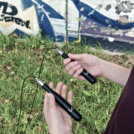 Person holding a jump rope with graffiti in the background