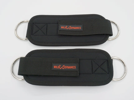 Two black ankle straps with metal rings and 'Wild Dynamics' branding on a white background