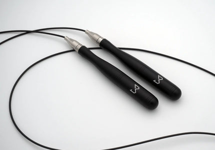 Black jump rope with silver ends on a white background