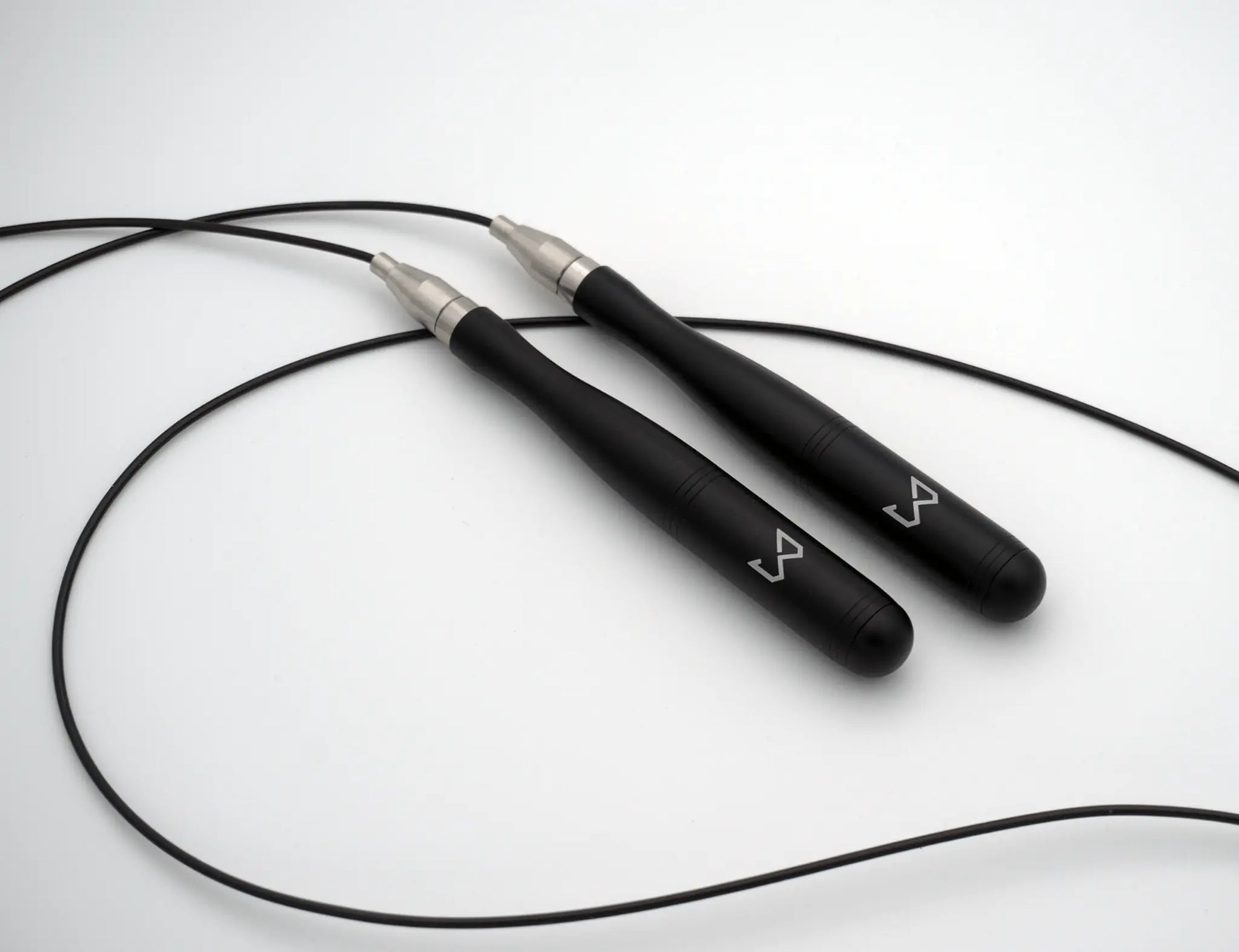 Black jump rope with silver ends on a white background