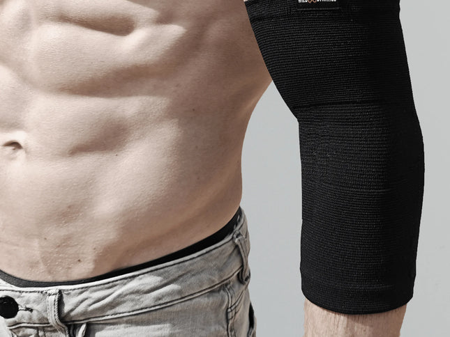 Person wearing a black elbow brace on a plain background