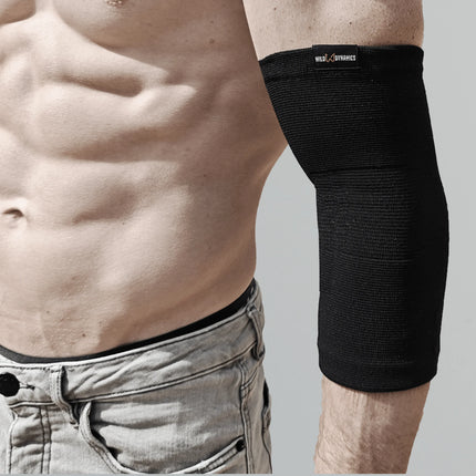 Person wearing a black elbow brace on a plain background